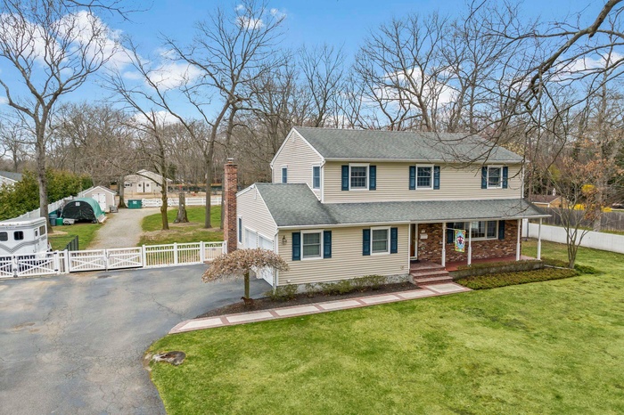Traditional-style home with a front lawn, fence, aphalt driveway, a porch, and a gate