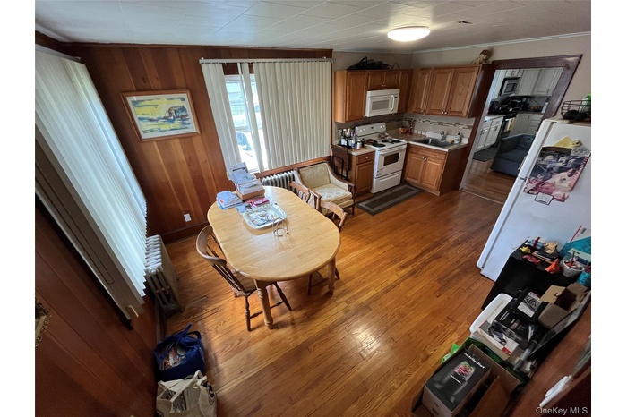 Dining room with wood walls and dark wood-type flooring