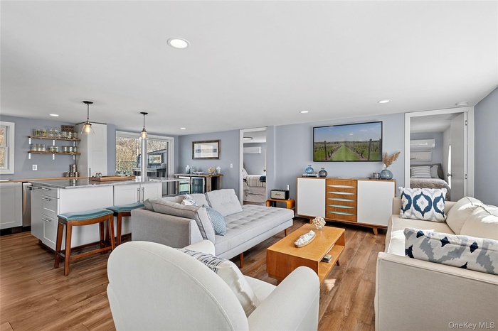 Living area featuring recessed lighting, wet bar, and light wood-style flooring