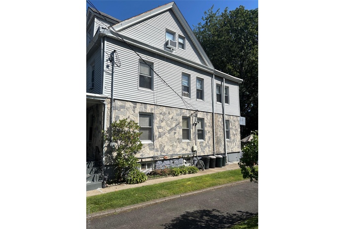 View of property exterior with stone siding