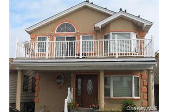 View of front of house featuring a balcony and stucco siding