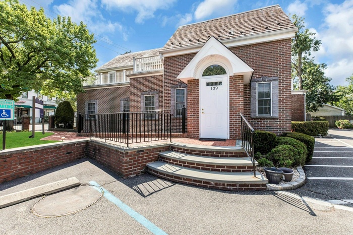 View of front of property with a high end roof and brick siding