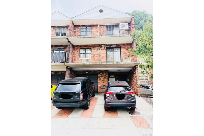 View of front of house featuring brick siding, driveway, and an attached garage