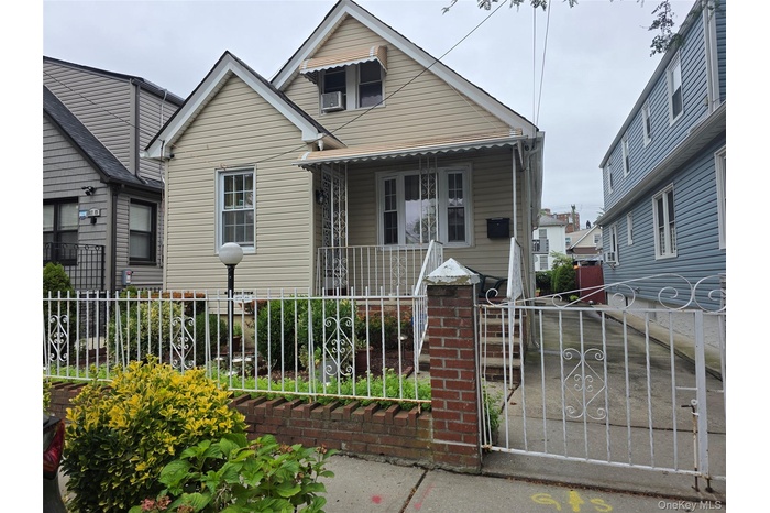 Bungalow-style home featuring a gate, a porch, and a fenced front yard