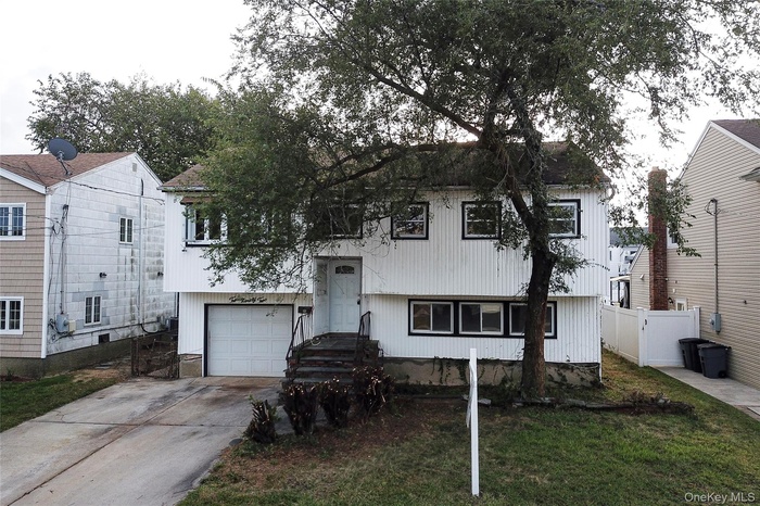 View of front of home with concrete driveway and an attached garage