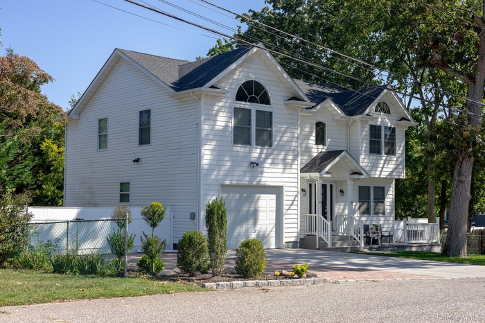 View of front of property with an attached garage, roof with shingles, and driveway
