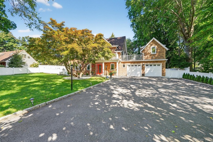 View of front of property featuring asphalt driveway and a garage