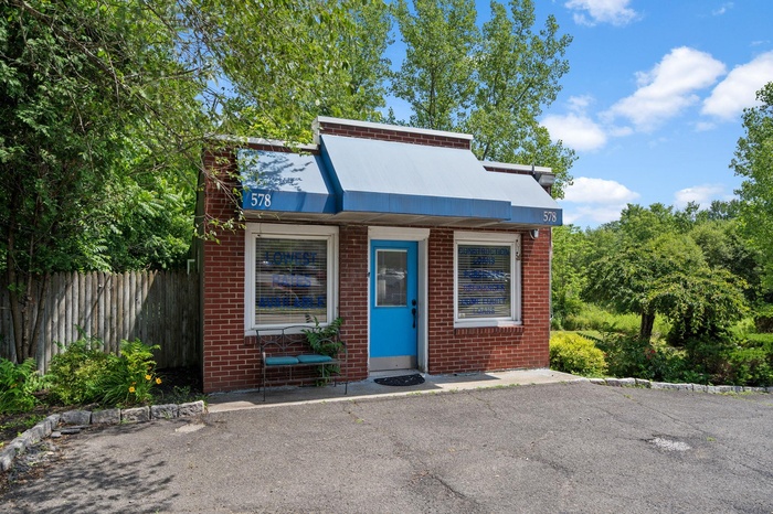View of front of property with fence and brick siding