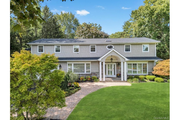 View of front of home featuring a front yard, french doors, a shingled roof, and stone siding