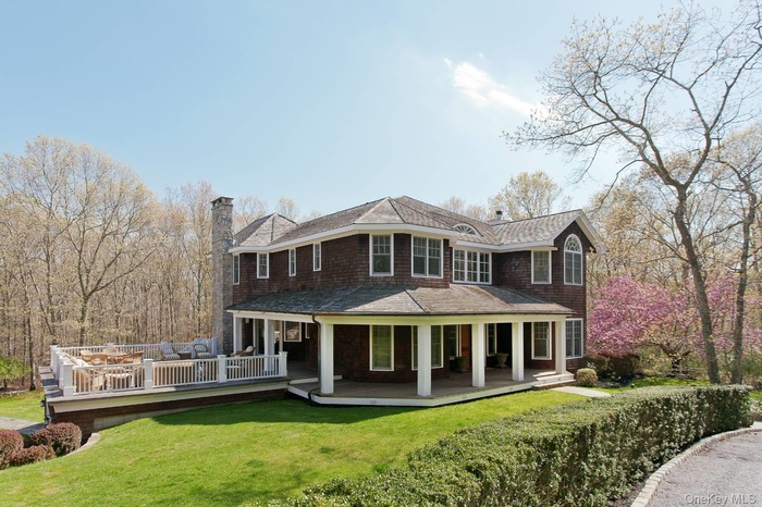 Rear view of property with a chimney, a lawn, and a shingled roof
