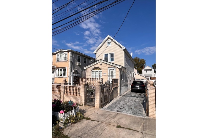 View of front of house with a fenced front yard, driveway, and a gate