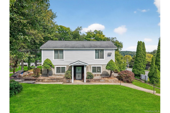 Colonial-style house with a front lawn and a shingled roof