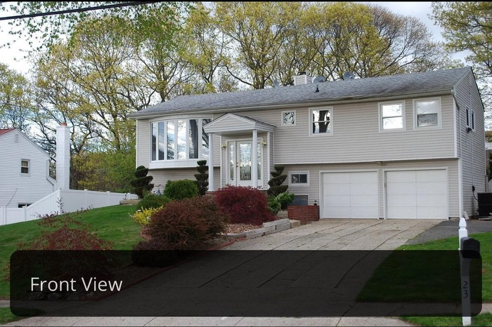 Bi-level home with a garage, cooling unit, fence, a chimney, and driveway