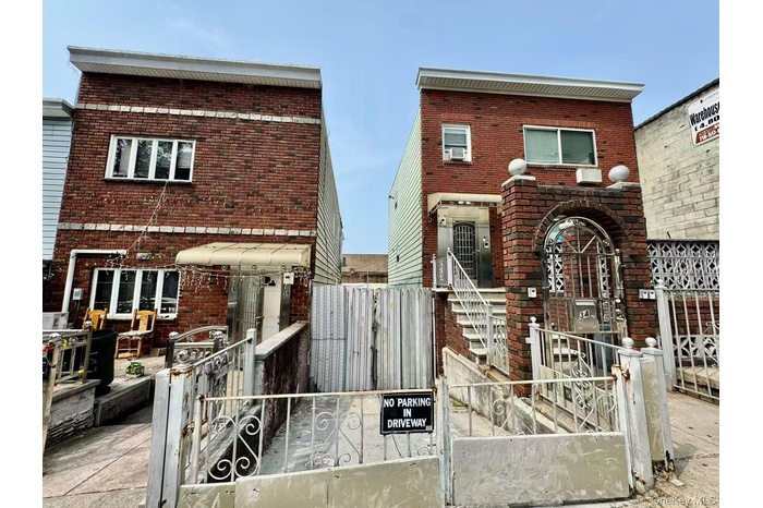 Traditional-style home with brick siding, a fenced front yard, and a gate