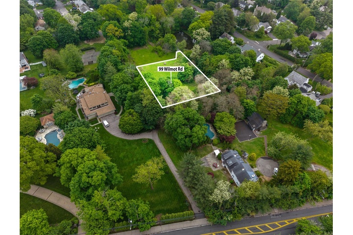 Aerial view of residential area with property parcel outlined and a pool