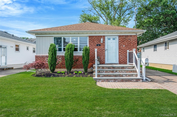 Bungalow-style house with a front lawn, brick siding, roof with shingles, and board and batten siding