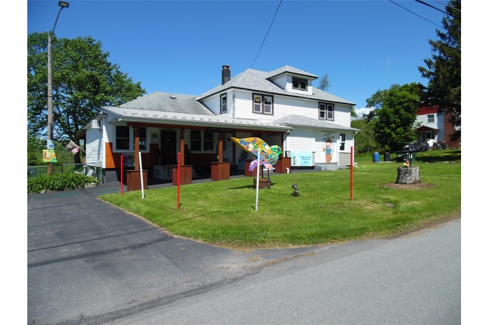 View of front of property with a chimney and a front yard