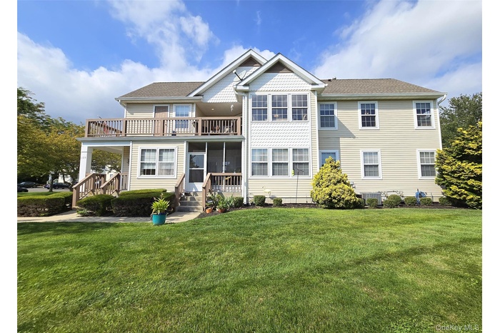 View of front facade featuring a wrap-around balcony, front lawn, a porch, and prime lake view.