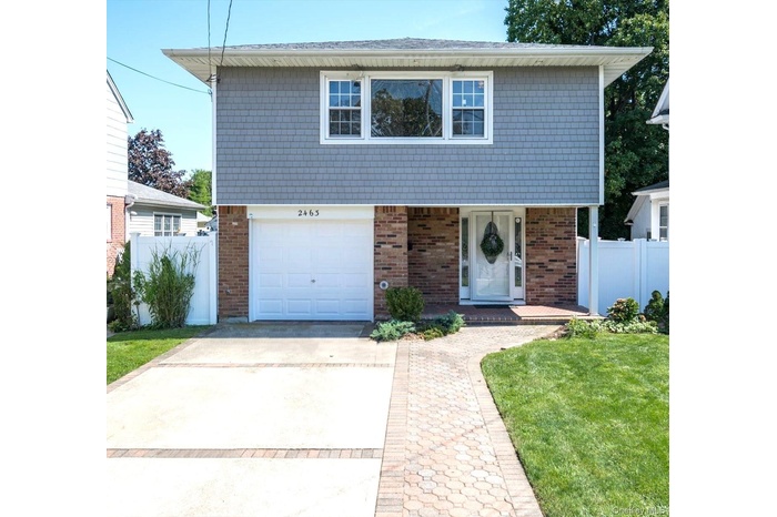 View of front facade featuring concrete driveway, brick siding, and a garage
