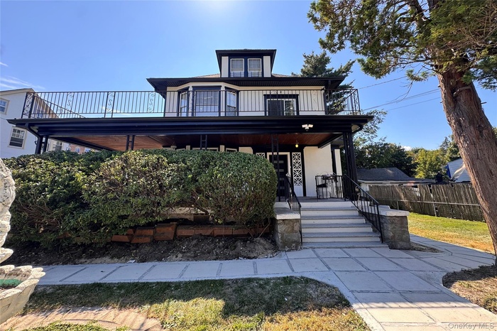 American foursquare style home with covered porch and stucco siding