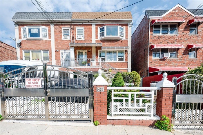 Traditional home with a gate, brick siding, and a fenced front yard