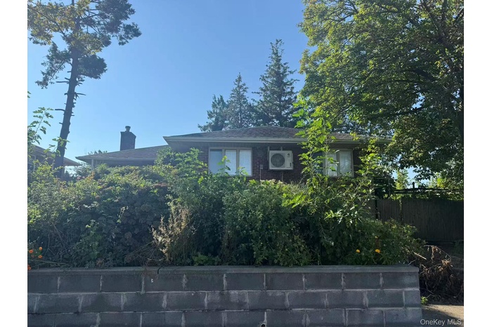 View of side of property with a cooling unit and brick siding