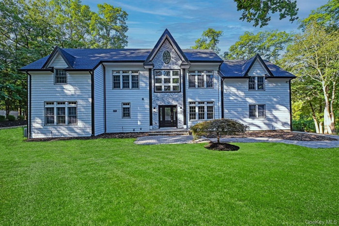 Back of house featuring a yard and stone siding