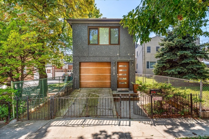 View of front facade with a gate, a fenced front yard, stucco siding, and concrete driveway