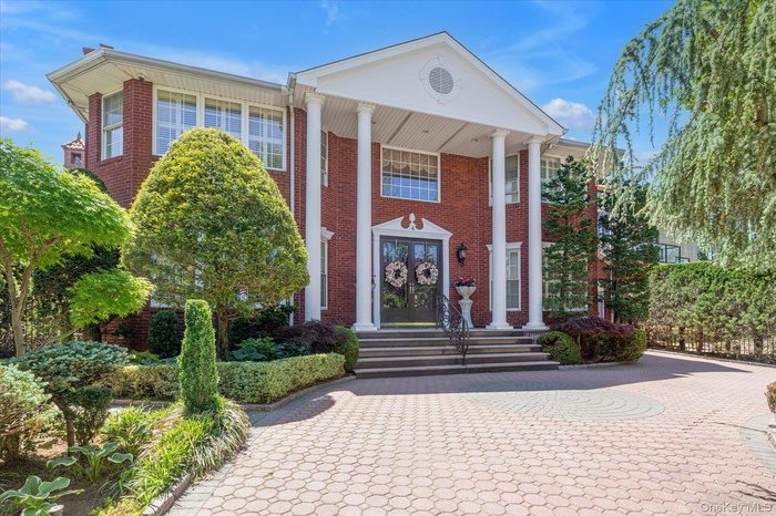 Greek revival house with french doors, brick siding, and curved driveway