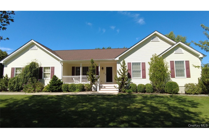 Ranch-style house featuring a porch and a front yard