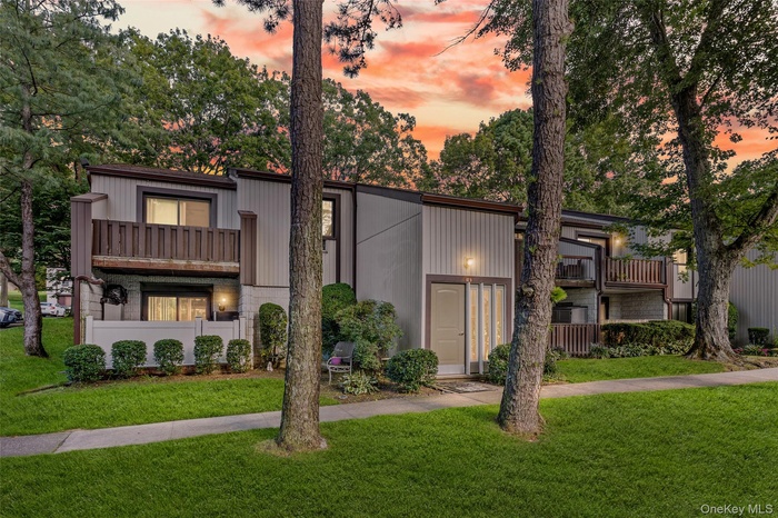 Mid-century modern home featuring a lawn and a balcony