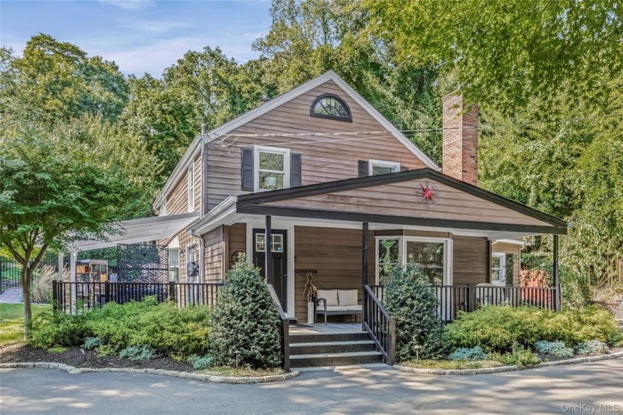 View of front of house with a porch and a chimney