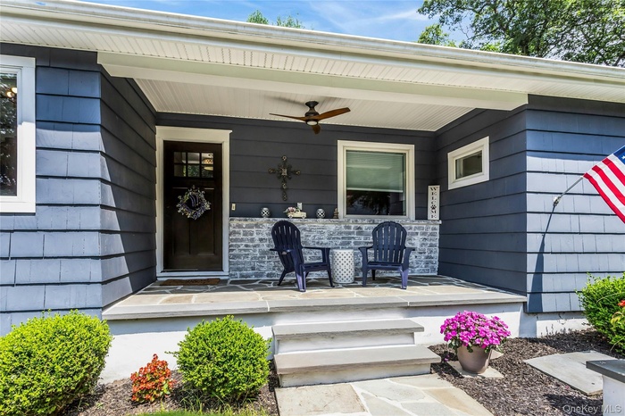 View of exterior entry with a porch and ceiling fan