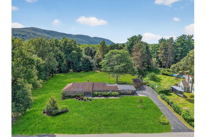 View from above of property with a heavily wooded area and mountains