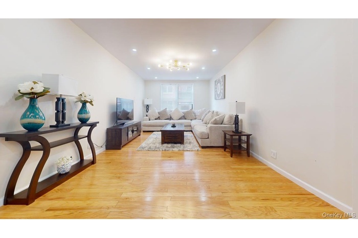 Living area with light wood-style flooring and recessed lighting