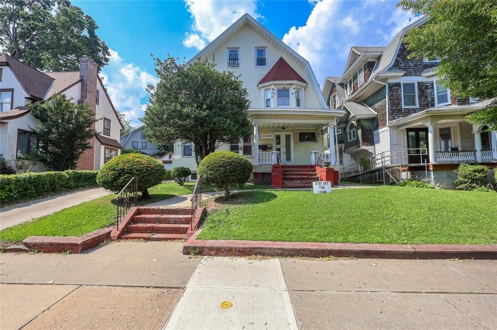 View of front of property with covered porch and a front lawn