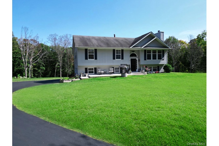 Raised ranch with a chimney and a front lawn