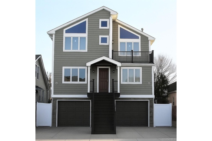 View of front facade featuring an attached garage, a balcony, and concrete driveway