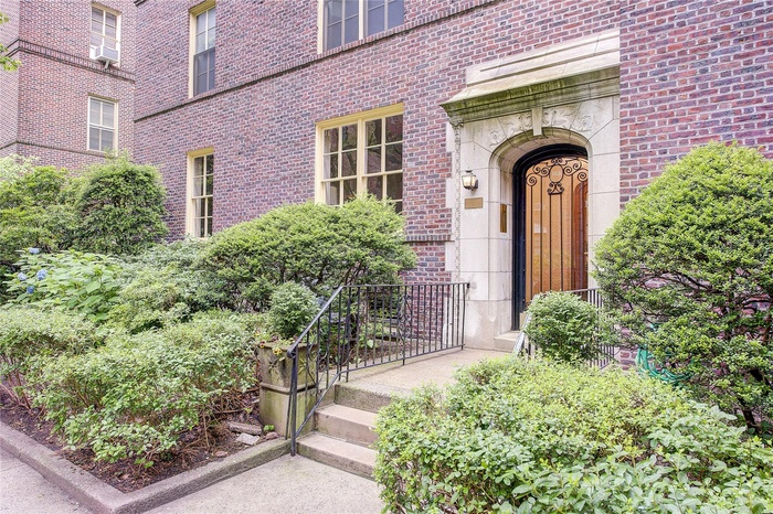 Property entrance with brick siding and cooling unit