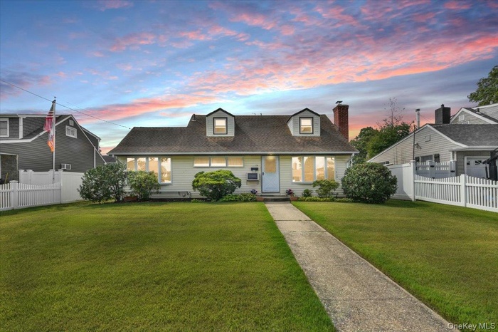 Cape cod house featuring a chimney and a shingled roof