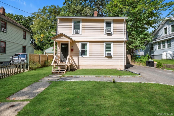 Colonial home with a chimney and asphalt driveway
