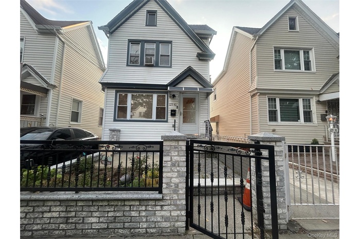 View of front of home featuring a fenced front yard and a gate