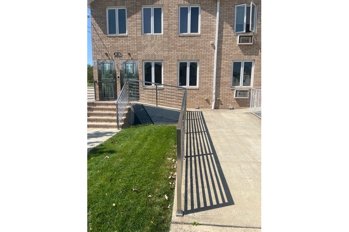 Doorway to property featuring brick siding and a lawn