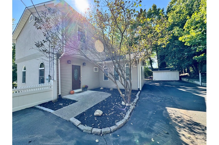 View of front of home featuring a patio and an outbuilding