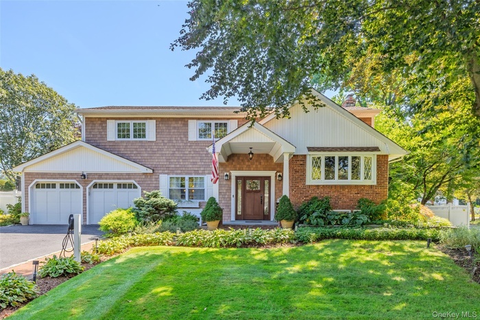 View of front of property with asphalt driveway, a front yard, and a chimney