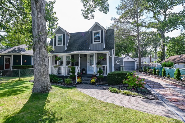 View of front of property featuring a porch and a shingled roof