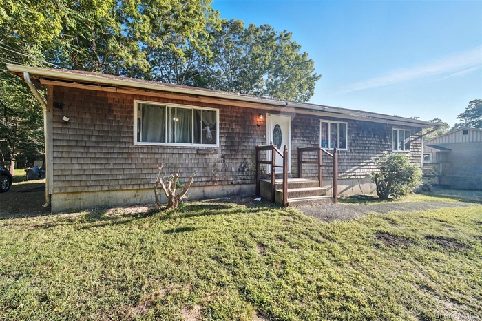 Ranch-style home featuring a front lawn