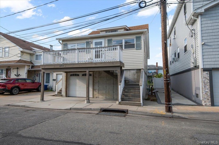 View of front facade featuring an attached garage and stairs