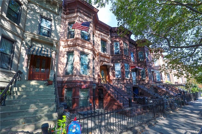View of property featuring a fenced front yard and stairway