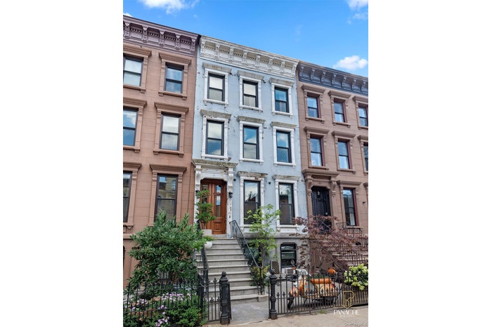 Italianate home with a fenced front yard